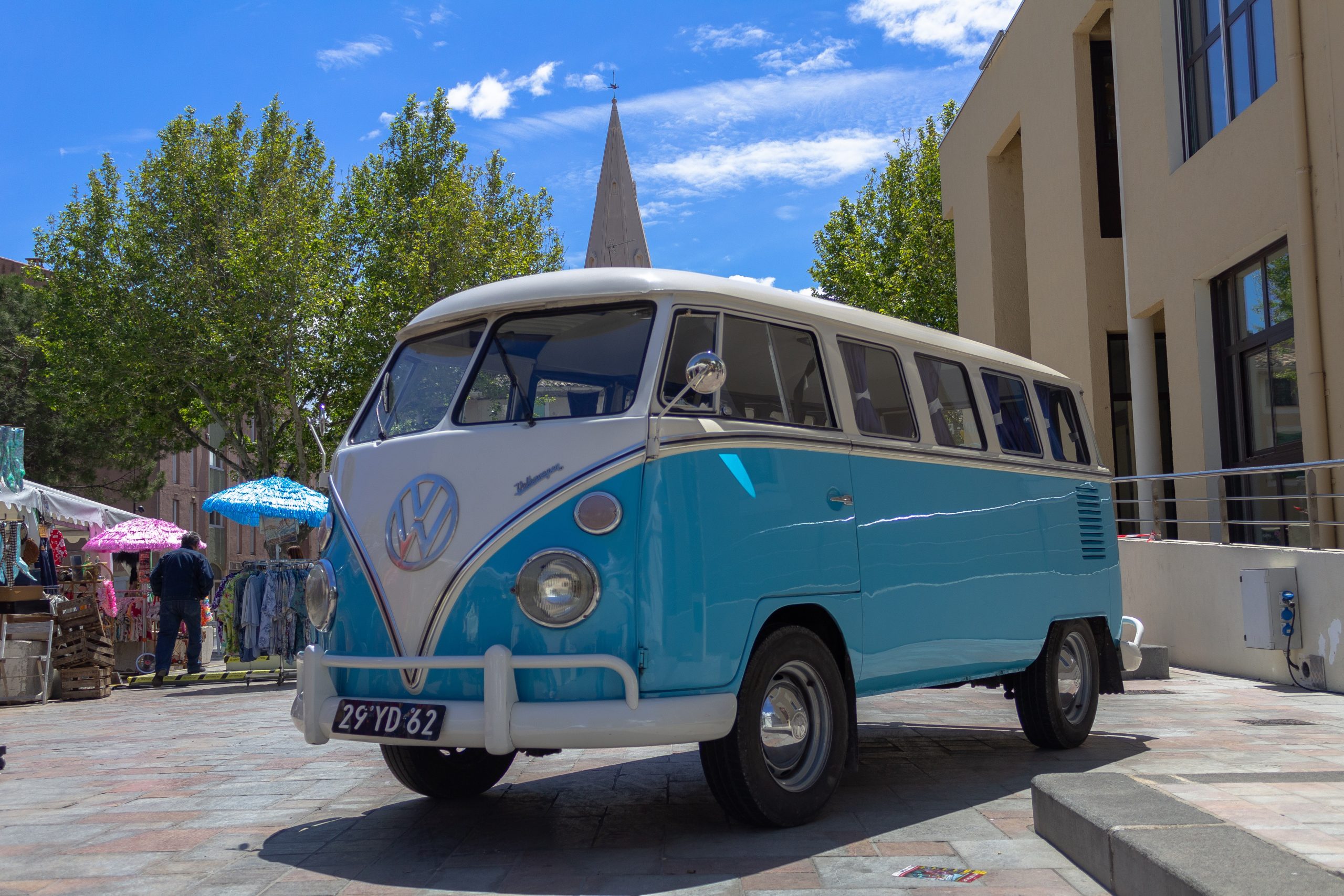 Blue and white VW camper van parked up in town centre.